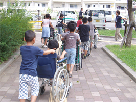 子供たちが車椅子を押す様子1
